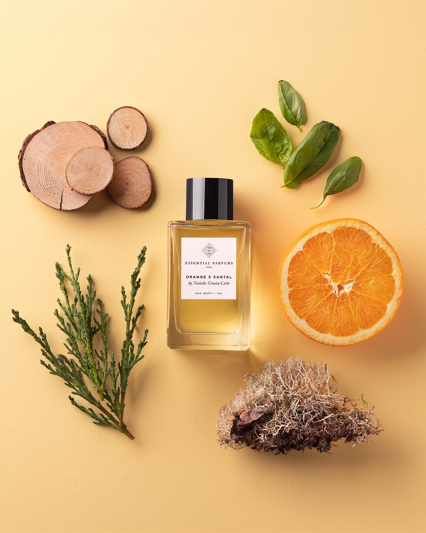 Essential Parfums Orange X Santal von Natalie Gracia-Cetto zwischen Orange, Sandelholzscheiben und Basilikum