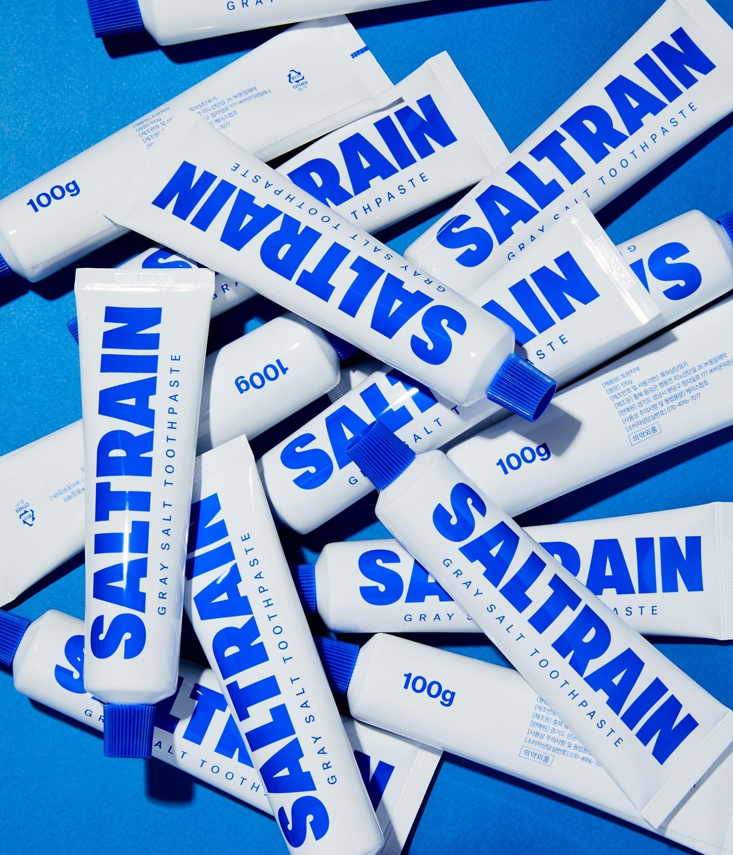 Saltrain Zahnpasta-Tuben auf blauem Grund