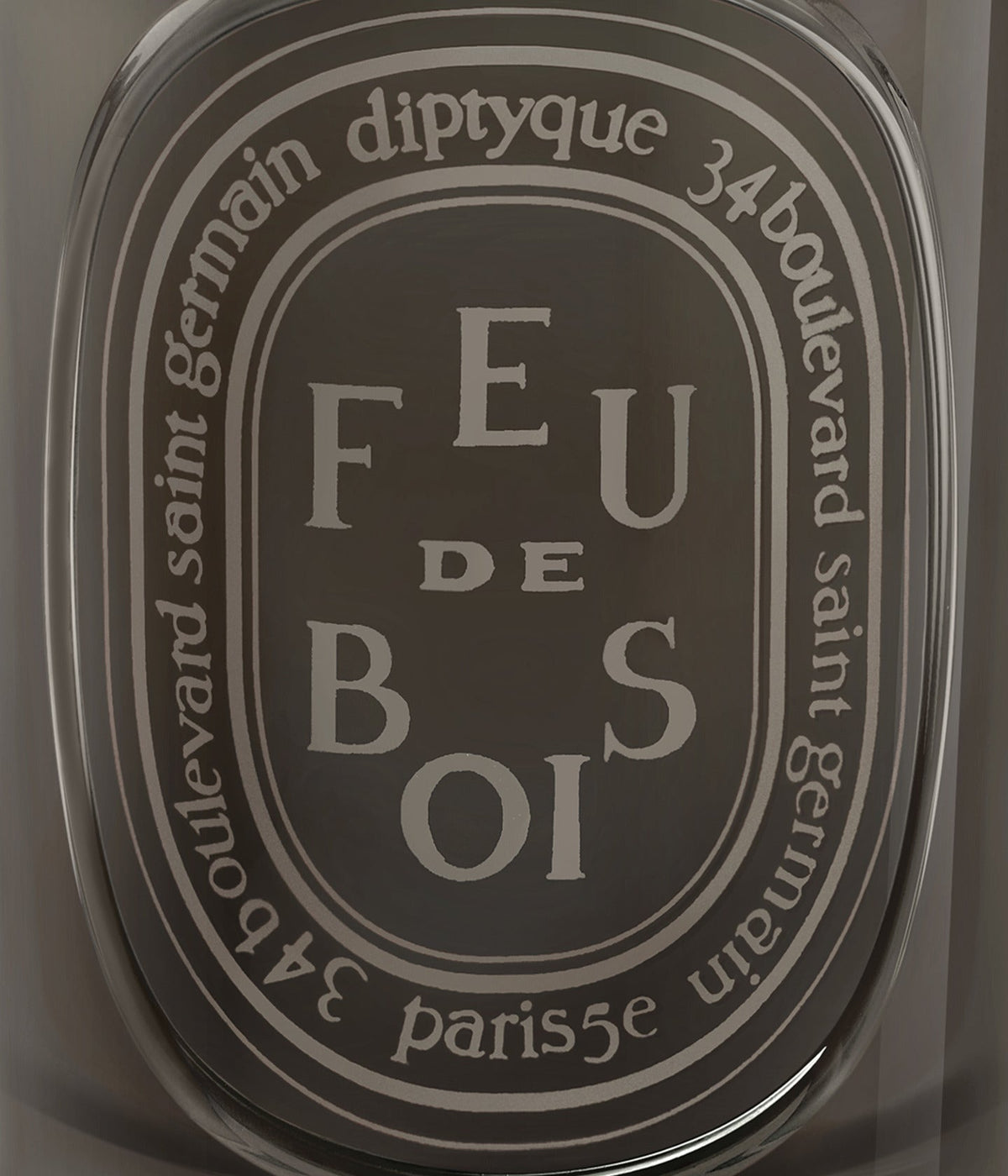 Diptyque Duftkerze Feu de Bois 300 g, graviertes Ovaletikett auf dunklem Glas