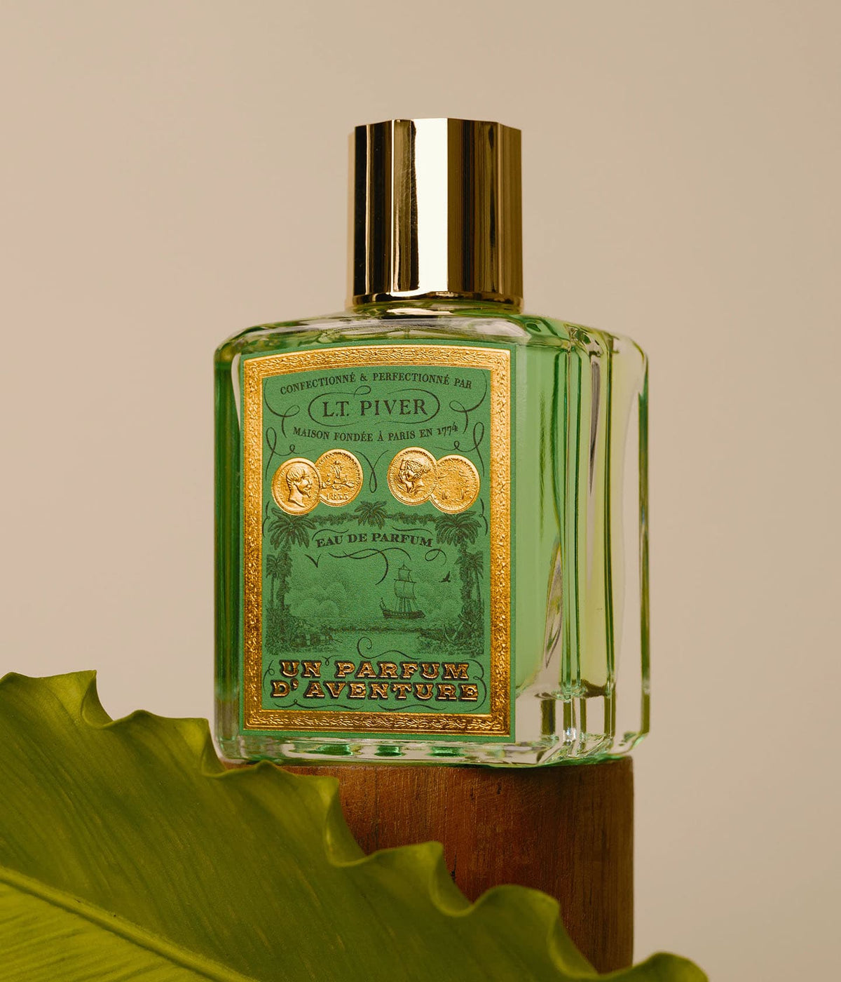 L.T. Piver Eau de Parfum Un Parfum d’Aventure auf einem Holzsockel mit Palmblatt