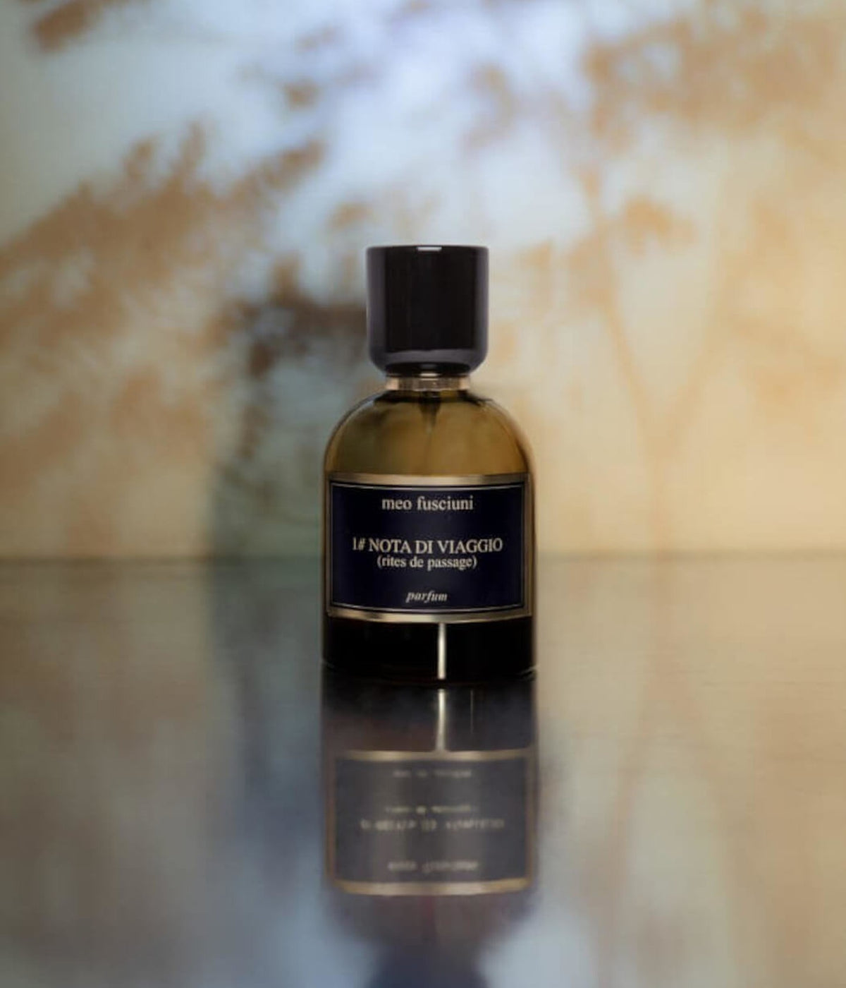 Meo Fusciuni Eau de Parfum #1 Nota di Viaggio (Rites de passage) auf spiegelnder Fläche vor warmem Licht mit Blätterschatten