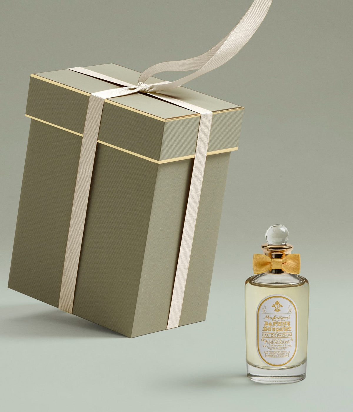 Penhaligon’s Eau de Parfum Daphne Bouquet, Flakon neben einer großen grünen Geschenkschachtel mit Schleife