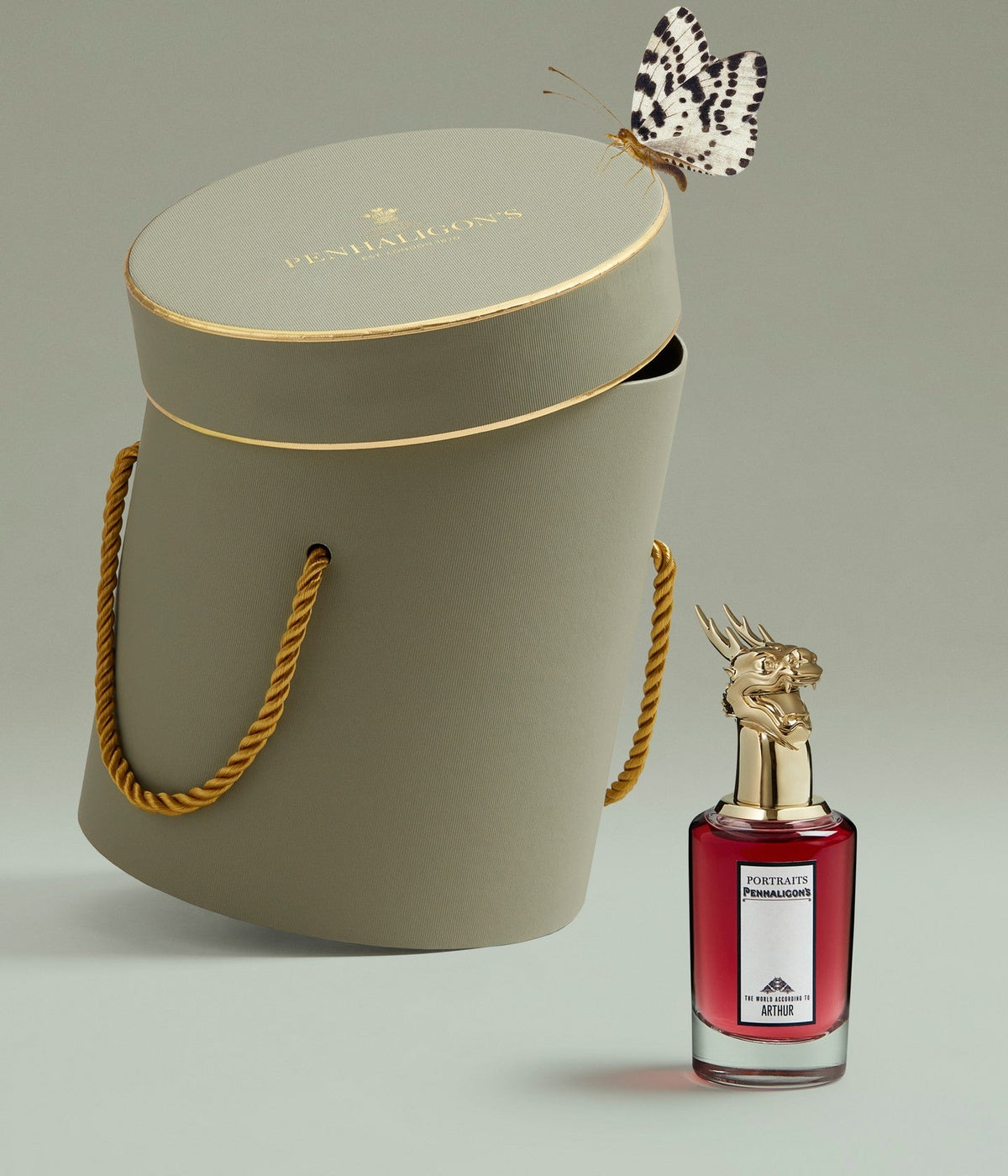 Penhaligon’s Eau de Parfum The World According to Arthur, Flakon mit goldenem Drachenkopf-Verschluss neben einer grünen Hutschachtel
