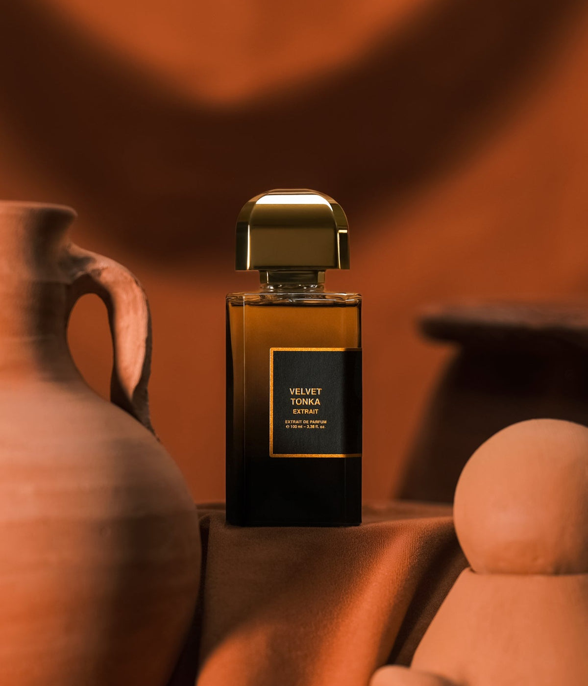 BDK Parfums Extrait de Parfum Velvet Tonka among clay vessels against terracotta fabric