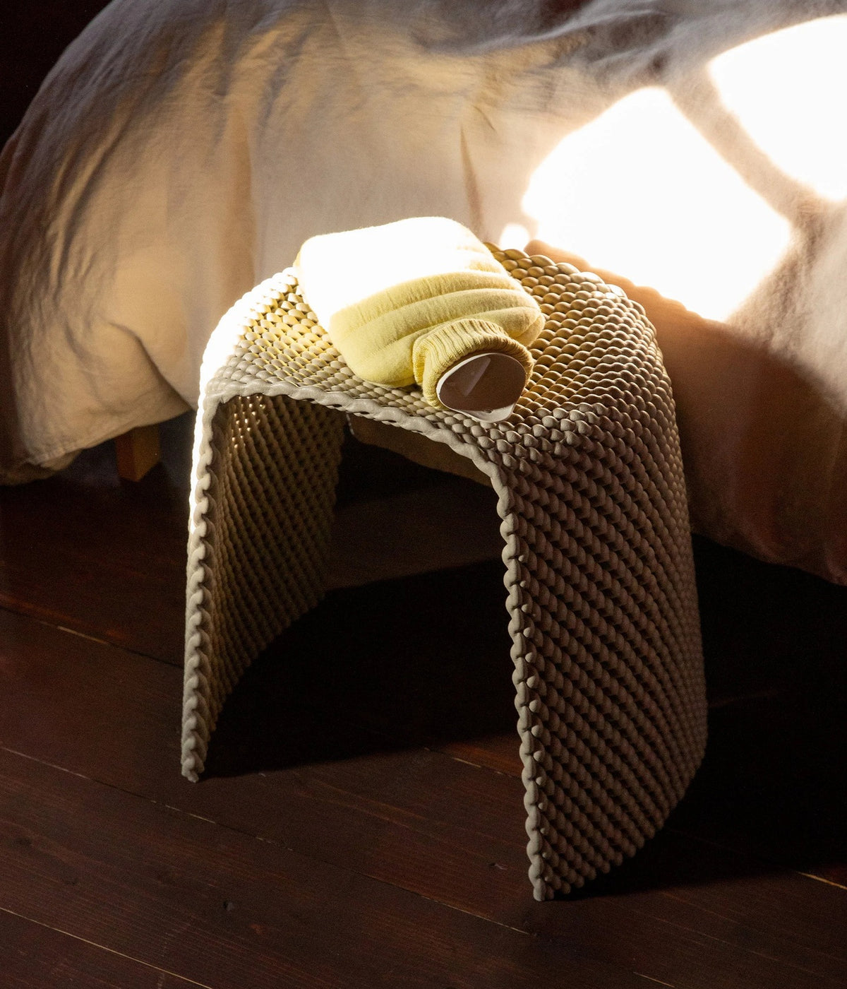 Wärmflasche Mini Puffy Butter Yellow – Suite702, auf einem Hocker